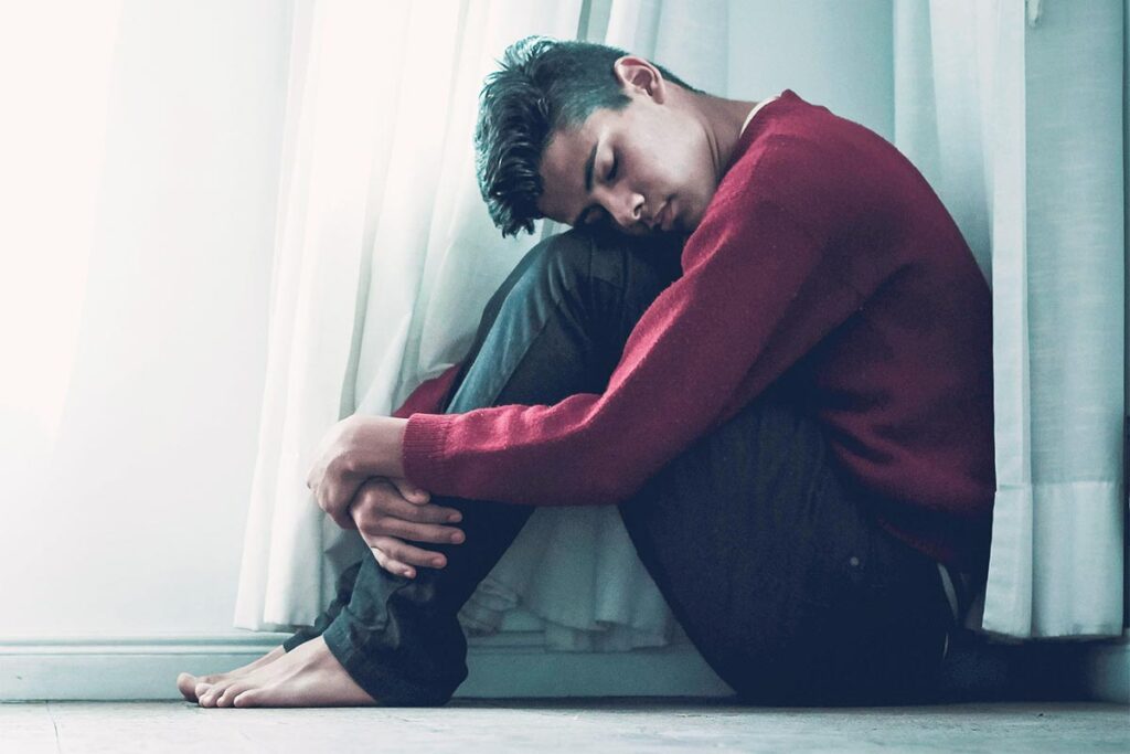 man with poor mental health sitting on floor