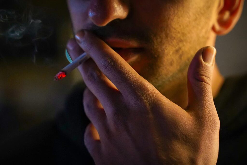 a man smoking tobacco in the dark