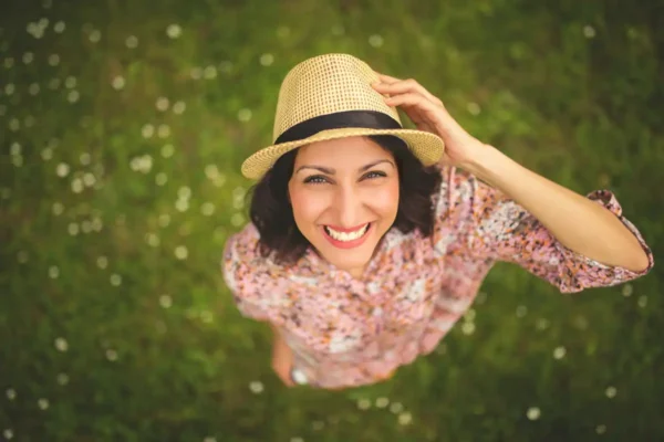 Portrait of beautiful happy young woman in the park,from above,toothy smile