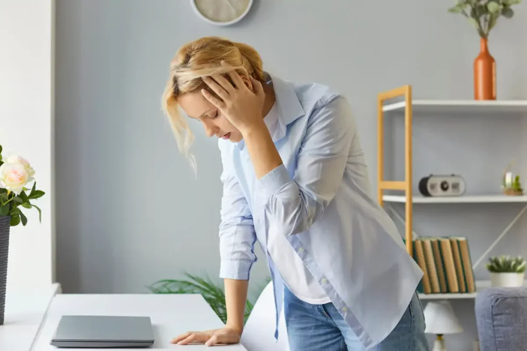 Stressed overworked woman suffering from terrible headache or dizziness