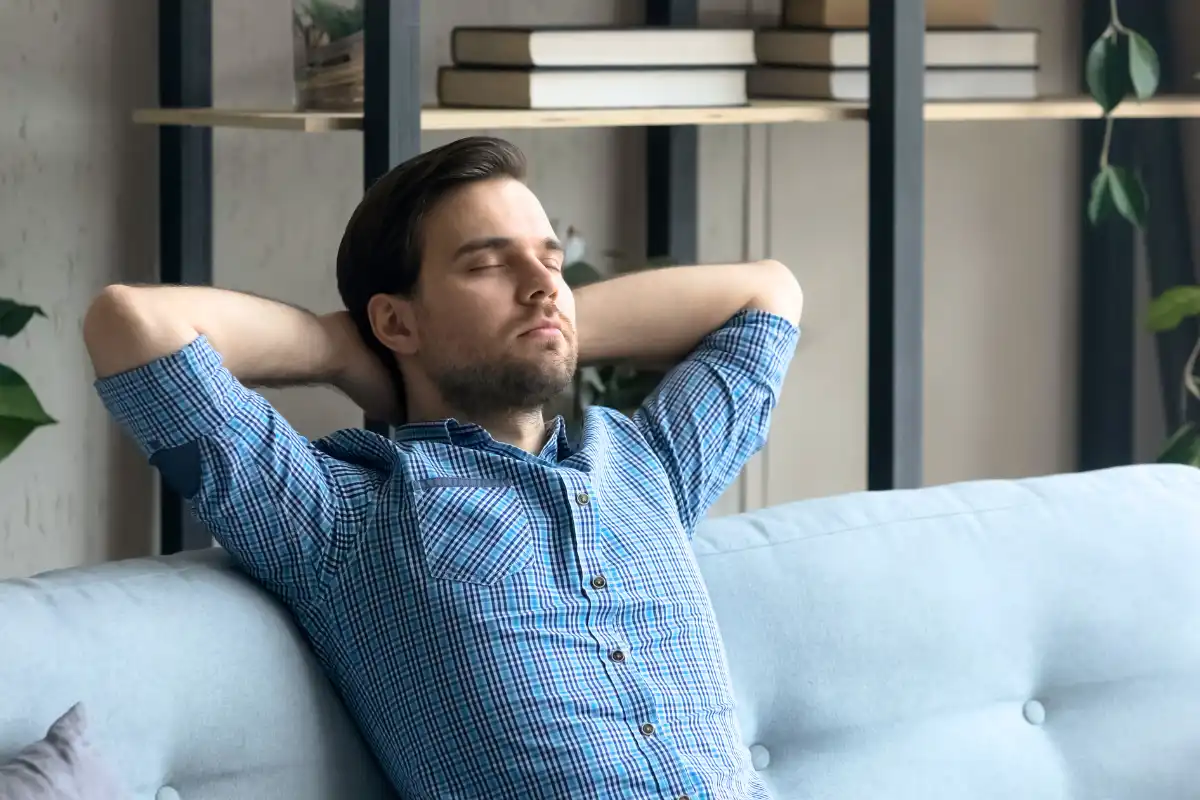 Young Calm Man Sit on Comfortable Sofa, Breathing slowly