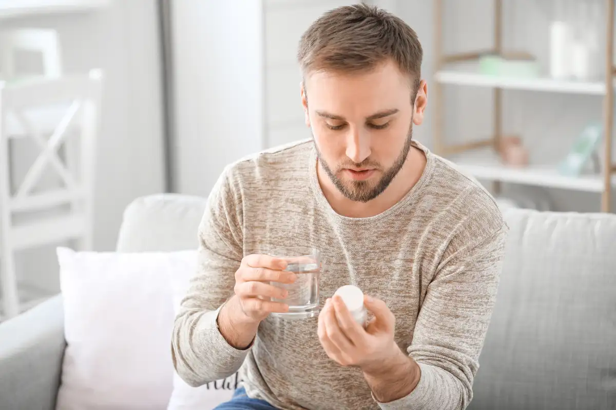 Young Man Taking Medicine at Home