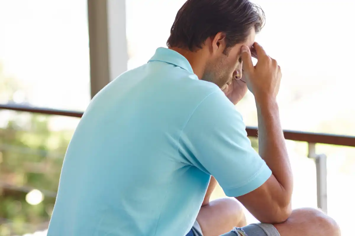 man sitting outside his house thinking a lot of things, concept of relapse