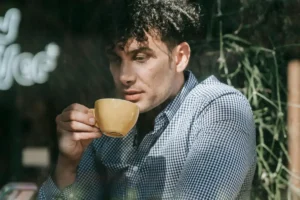 Man Drinking Coffee by the Cafe Window