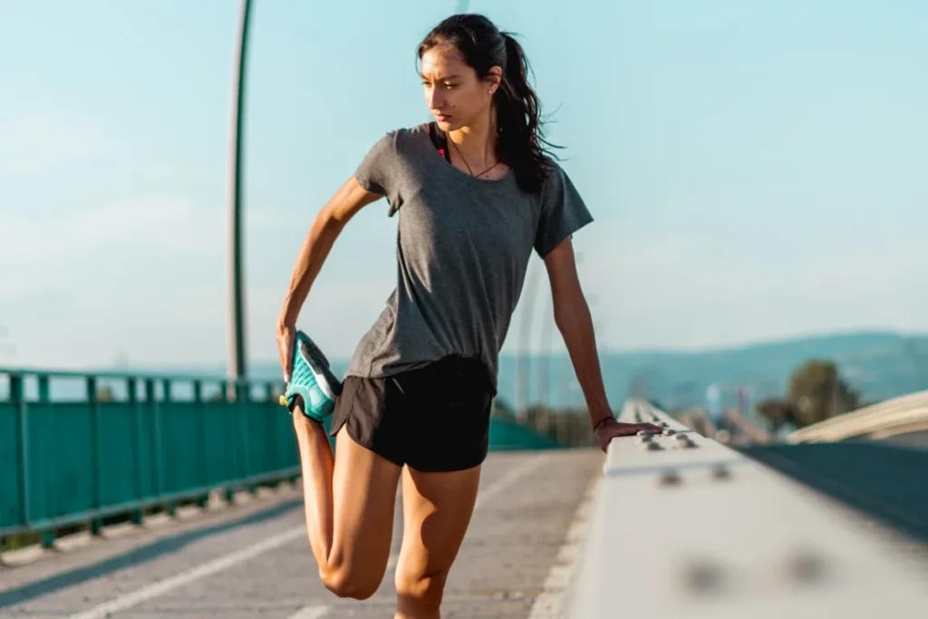 Young woman stretching legs after hard workout