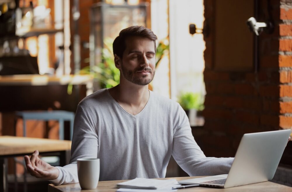 Male in the office pausing and breathing mindfully