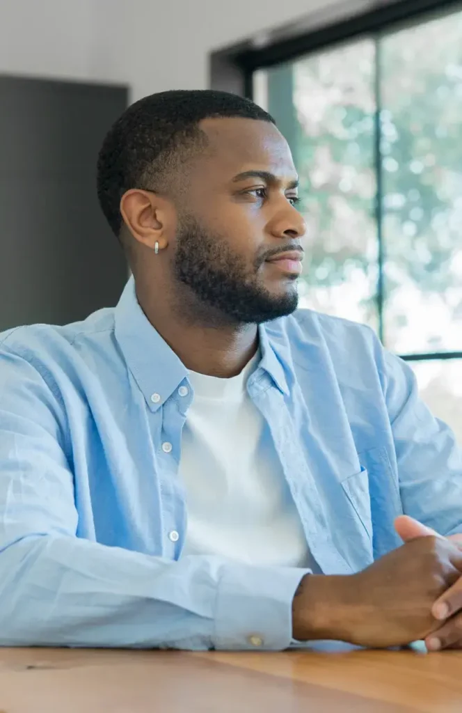 contemplative man sitting at a wooden table in bri 2026 06 15 19 35 37 utc Large - Addiction Treatment at Reviving You Recovery